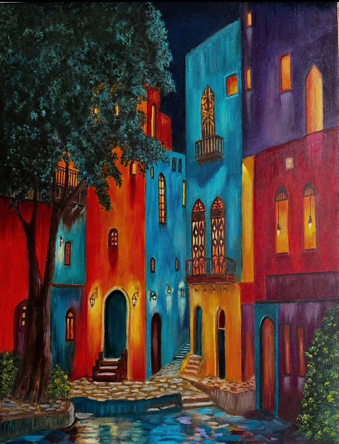 Colorful street scene with buildings and a tree at night